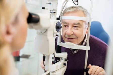 An elderly man has his eyes checked by an ophthalmologist.  Choacupuncture.com